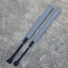 40" Foam Fighting weapons for larp sports with black handles and grey Ripstop covers laying on the concrete for comparison between the flat down stick and the Omni stupid long bat versions.
