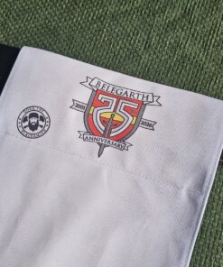 Passport Belt Flag for Belegarth Silver Jubilee - Close up of belt flag on black leather belt against a green tunic backgroup