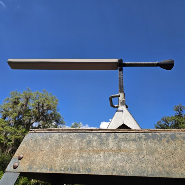 A foam sword rests on a jack stand with a blue sky in the background